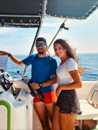 Friendly crew members – skipper and guide – smiling aboard a speedboat during the Blue Cave & Hvar Tour from Split