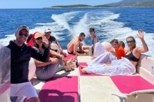Guests relaxing on pink speedboat during blue cave tour